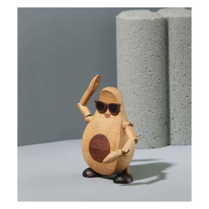 Spring Copenhagen Alfredo – träfigur i form av en avokado med solglasögon, rörliga armar och ben, poserande mot grå bakgrund.