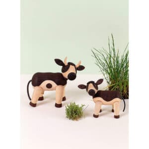Spring Copenhagen Daisy ko i trä med kalv, handgjorda träfigurer i naturfärger, stående i miljö med grönt gräs och vit bakgrund.