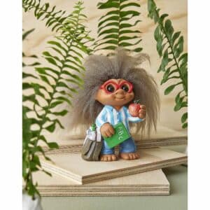 Spring Copenhagen Lyckotroll Lärare med rufsigt hår, röda glasögon,randig skjorta, blå byxor, bok och äpple i handen, stående bland gröna ormbunksblad.