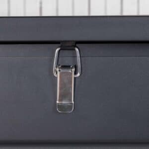 Närbild på ett silverfärgat snäpplås i metall monterat på en svart dynbox